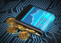 A smartphone displaying cryptocurrency exchange rates rests on a circuit board background, with gold Bitcoin coins partially underneath it, symbolizing digital currency and electronic trading. | FintechZoom