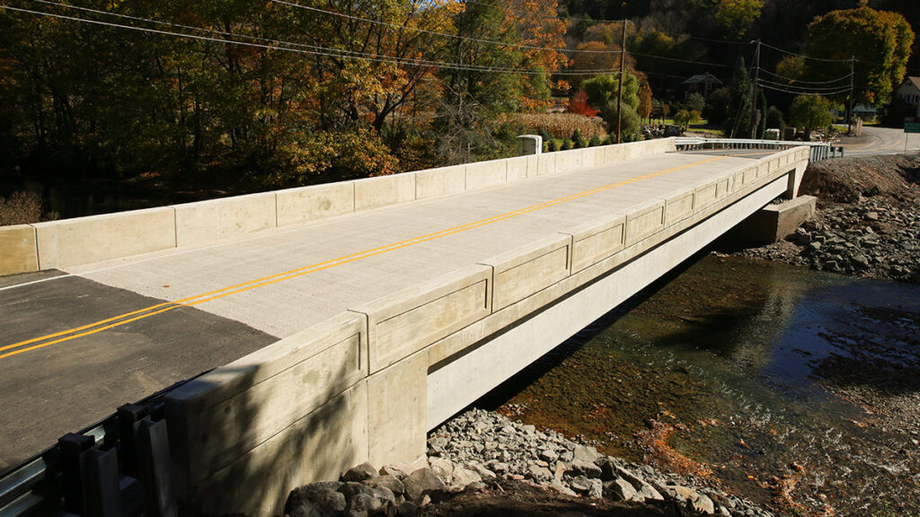 A bridge over a river, part of Pennsylvania’s Rapid Bridge Replacement initiative, provides safe and efficient passage while blending seamlessly into the natural landscape. | FintechZoom
