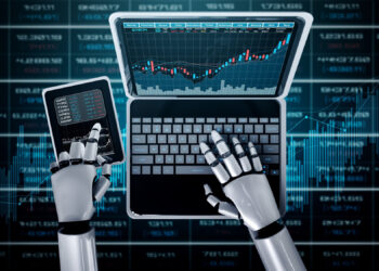 A robot with metallic hands uses a laptop and holds a smartphone displaying financial data, with stock market charts and numbers shown on the computer screens and background. | FintechZoom