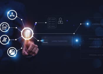 A person in a suit touches a virtual fingerprint icon on a digital interface, surrounded by data security and analytics icons, representing secure digital access and data management. | FintechZoom