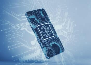 A digital illustration of a smartphone with a microchip displaying a brain symbol on its screen, surrounded by glowing circuit lines, representing artificial intelligence technology. | FintechZoom