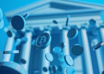 Blue-toned image showing digital coins with the Bitcoin symbol falling in front of a classical bank building with columns, representing cryptocurrency and financial institutions. | FintechZoom