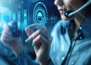 A woman wearing a headset touches a transparent virtual screen with digital icons and data, representing advanced technology and digital communication. | FintechZoom