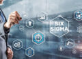 A man in a suit interacts with virtual hexagonal icons related to business and analytics, with "Six Sigma" highlighted at the centre against a blurred cityscape background. | FintechZoom