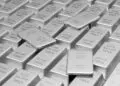Stacks of shiny silver bars, each labelled "FINE SILVER 999.9 NET WT 1000g," arranged in neat rows with a few bars slightly tilted on top of others. | FintechZoom