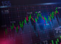 A digital stock market chart displays green and red candlesticks, numbers, and trend lines on a dark background, indicating fluctuating prices and trading activity. | FintechZoom
