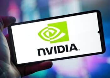 Close-up of a hand holding a smartphone showing the NVIDIA logo on screen with a blurred background.