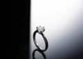 A solitaire diamond engagement ring with a dark band set against a contrasting black and white background. | FintechZoom